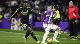 Bek  Real Valladolid Ivan Fresneda ditantang oleh penyerang Real Madrid Vinicius Junior dalam duel pekan ke-15 La Liga 2022/23 di Stadion Nuevo Jose Zorrilla, Valladolid, Sabtu (31/12/2022) dini hari WIB. Real Madrid menang 2-0 berkat dua gol Karim Benzema. (AP Photo/Pablo Garcia)