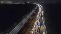 Foto udara ini menunjukkan kendaraanroda empat tersendat saat melintasi&nbsp; Jalan Tol Jakarta - Cikampek di Karawang, Jawa Barat pada 28 April 2022. Lalu lintas di Jalan Tol Jakarta-Cikampek mengalami kemacetan panjang memasuki puncak arus mudik Lebaran 2022. (BAY ISMOYO / AFP)