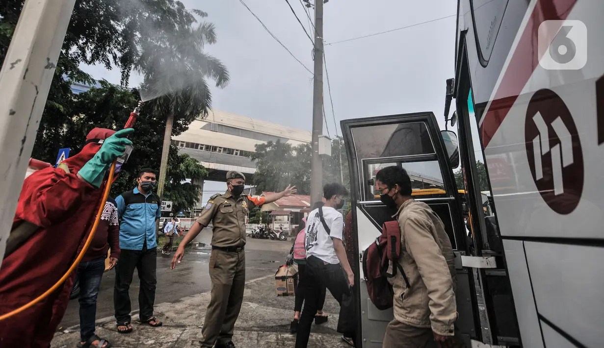 Petugas pemadam kebakaran menyemprotkan disinfektan kepada penumpang bus AKAP di Terminal Kampung Rambutan, Jakarta, Minggu (23/5/2021). Penyemprotan rutin dilakukan kepada bus AKAP dan penumpang selama arus mudik Lebaran sebagai langkah mencegah penyebaran Covid-19. (merdeka.com/Iqbal S Nugroho)