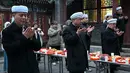 Di kota-kota dengan populasi Hui yang besar, seperti Linxia, suasana Ramadan terasa sangat kental dengan aktivitas berbagi sahur dan buka puasa bersama. Tampak dalam foto, warga Muslim etnis Hui Tiongkok membaca doa sebelum berbuka puasa di sebuah masjid selama minggu terakhir bulan suci Ramadhan di Beijing pada 17 Maret 2026. (Adek BERRY/AFP)