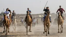 Tujuh peserta joki  bersaing dalam perlombaan balap unta lokal di Rafah, Jalur Gaza selatan (20/10/2019). Balapan unta ini menggunakan lintasan bekas landasan bandara Gaza yang sudah hancur di Rafah, Gaza selatan. (AFP Photo/Said Khatib)