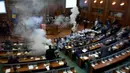 Sebuah gas air mata meledak dalam rapat parlemen di ibu kota Kosovo, Pristina, Rabu (21/3). Aksi anggota Partai Vatevendosje itu dilakukan demi mencegah pemungutan suara terkait masalah kesepatakan perbatasan dengan Montenegro. (AP Photo/Visar Kryeziu)