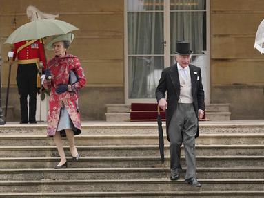 Pangeran Kerajaan Inggris Charles (tengah), Duchess of Cornwall Camilla (kanan), dan Putri Anne (kiri) berjalan menuruni tangga saat Pesta Taman Kerajaan yang diadakan di Istana Buckingham, London, Inggris, 11 Mei 2022. (Jonathan Brady/Pool Photo via AP)