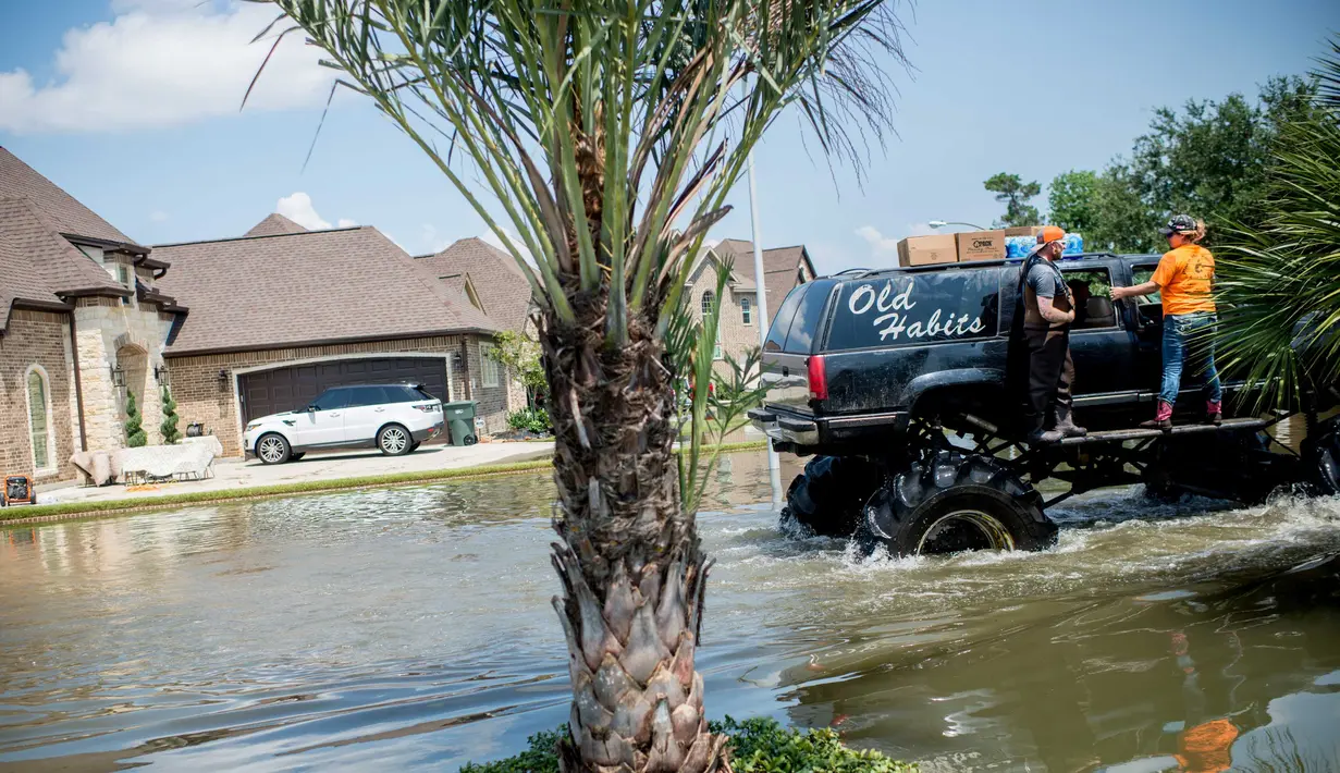 Truk monster menerobos genangan air saat membantu warga yang menjadi korban Badai Harley di Port Arthur, Texas, AS (1/9). Truk raksasa ini menjadi salah satu kendaraan yang diandalkan usai Badai Harley menghantam Texas. (AFP Photo/Emily Kask)