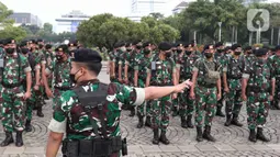 Prajurit TNI bersiap mengikuti apel gabungan gelar pasukan di Silang Monas, Jakarta, Senin (11/4/2022). Polda Metro Jaya mengerahkan sebanyak 5.620 pasukan gabungan Polri-TNI dalam rangka pengamanan aksi unjuk rasa BEM SI. (Liputan6.com/Herman Zakharia)