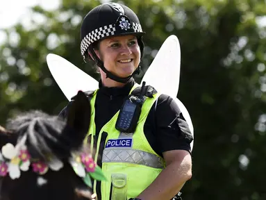 Polisi wanita bersayap peri melakukan patroli menggunakan kuda di lokasi Festival Glastonbury, Worthy Farm, Somerset, Inggris, 25 Juni 2015. (REUTERS/Dylan Martinez)
