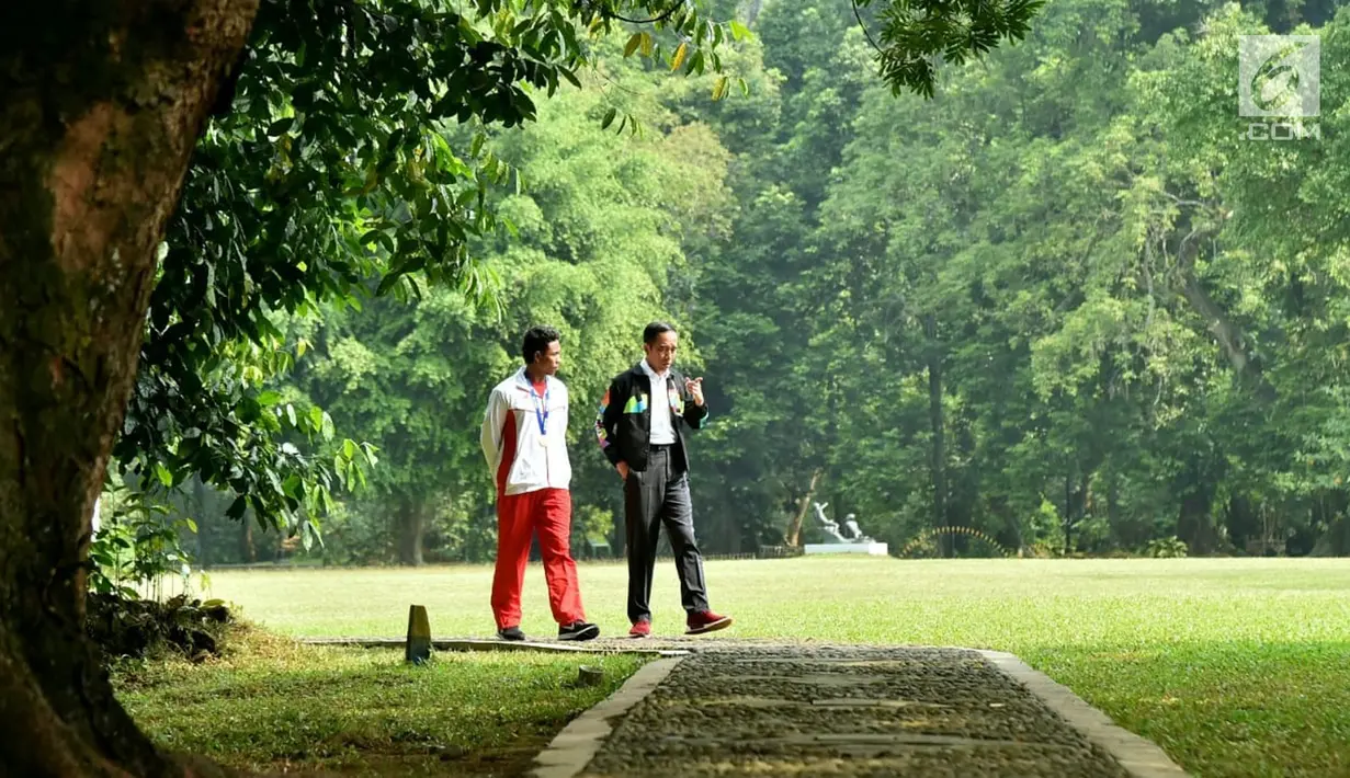 Presiden Joko Widodo atau Jokowi (kanan) dan sprinter Lalu Muhammad Zohri (kiri) berjalan santai di Istana Bogor, Jawa Barat, Rabu (18/7). Jokowi menyatakan kebanggaannya atas prestasi yang diraih oleh Zohri. (Liputan6.com/Pool/Biro Pers Setpres)