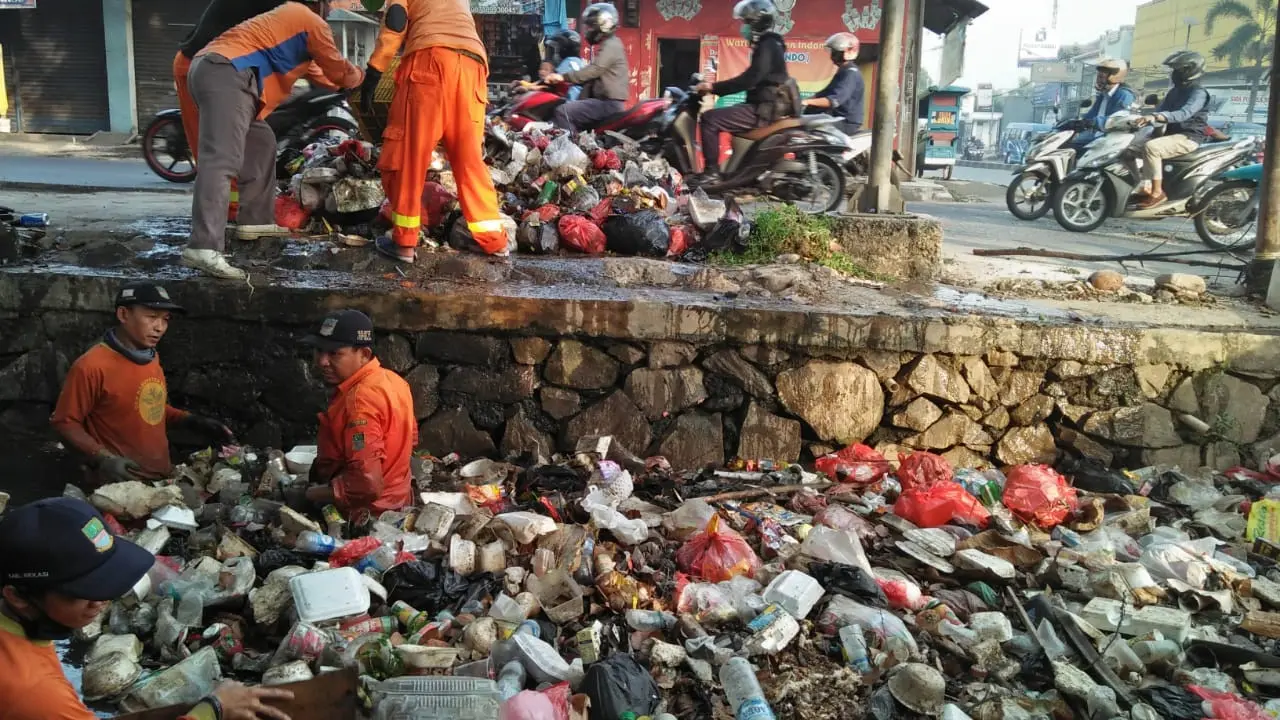 Petugas membersihkan tumpukan sampah kali Abu Bakar Bekasi (Bam Sinulingga/Liputan6.com)