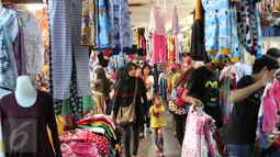Sejumlah pembeli mencari berbagai kebutuhan berupa pakaian di Pasar Tanah Abang, Jakarta, Rabu (9/12). Libur pilkada dimanfaatkan warga untuk berbelanja pakaian di pasar tekstil terbesar di Asia Tenggara itu. (Liputan6.com/Angga Yuniar)