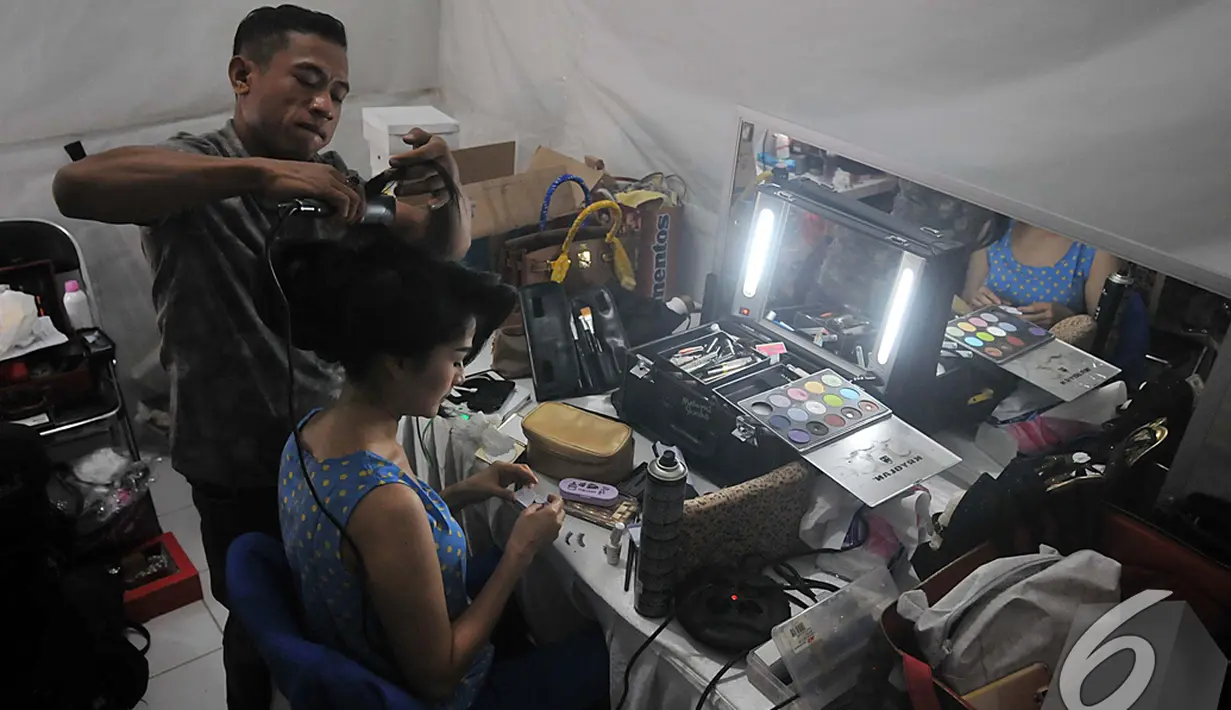 Seorang penata rambut sedang menata rambut Iis Dahlia agar tampil memesona di ajang SCTV Awards 2014. Foto diambil pada Sabtu (29/11/2014). (Liputan6.com/Johan Tallo)