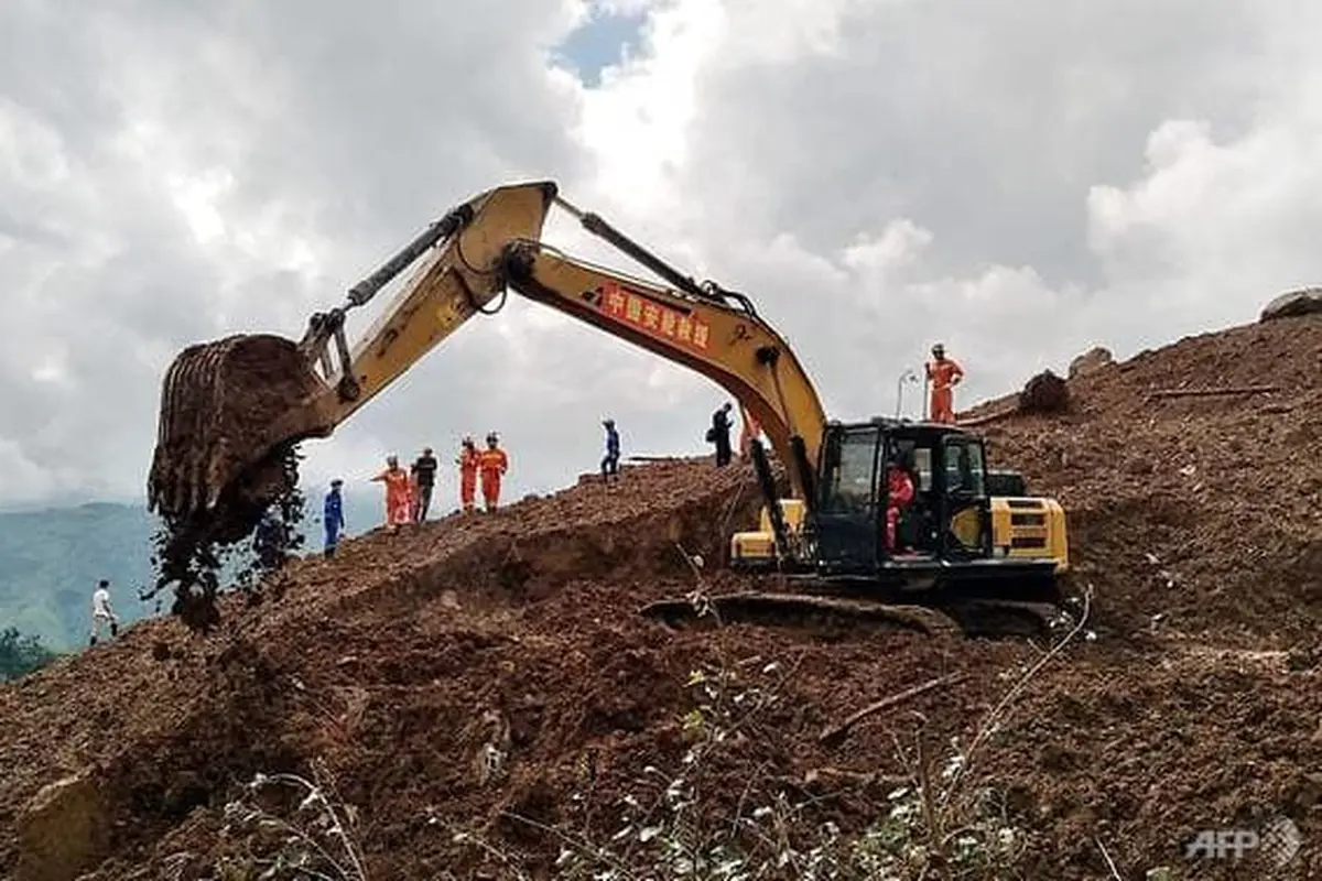 Sebuah ekskavator dan penyelamat bekerja di lokasi tanah longsor di Liupanshui, Provinsi Guizhou, Barat Daya China, 24 Juli 2019. (AFP / STR)