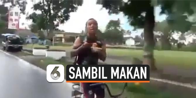 VIDEO: Viral, Pria Naik Sepeda Sambil Makan Mi Ayam