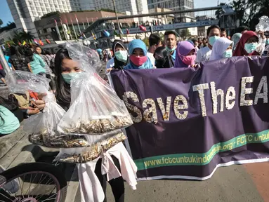 Aktivis Gerakan Muda FCTC melakukan aksi mengumpulkan puntung rokok di kawasan Bundaran HI, Jakarta, Minggu (26/4/2015). Kegiatan tersebut untuk memperingati Hari Bumi. (Liputan6.com/Faial Fanani)