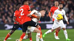 Pemain Manchester United, Rasmus Hojlund, berusaha melewati pemain Luton Town, Gabriel Osho, dalam duel pekan ke-25 Premier League di Kenilworth Road, Minggu (18/2/2024). (AFP/Glyn Kirk)