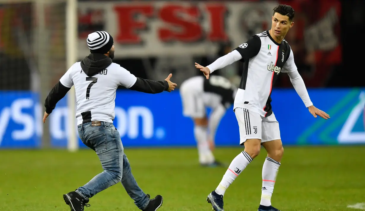 Seorang penyusup masuk ke lapangan untuk memeluk Cristiano Ronaldo saat laga Juventus melawan Bayer Leverkusen pada pertandingan Liga Champions di Bay Arena, Leverkusen, Jerman, Rabu (11/12/2019). (AP Photo/Martin Meissner)