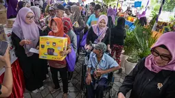 Tidak hanya bahan pangan, Gabungan Organisasi Wanita (GOW) juga memberikan barang-barang peralatan rumah, seperti panci, penggorengan, dan alat dapur lainnya. Tampak dalam foto, masyarakat menerima barang-barang gratis seperti pakaian, bahan makanan pokok, dan perlengkapan rumah tangga yang disediakan oleh Asosiasi Organisasi Wanita (GOW) dan pemerintah daerah selama kegiatan aksi sosial tahunan di bulan Ramadan, Surabaya pada Senin 2 Maret 2026. (JUNI KRISWANTO/AFP)