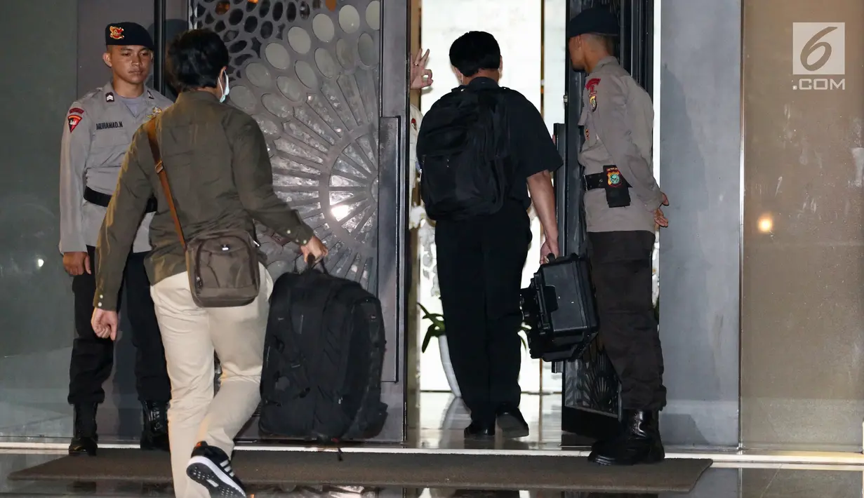 Dua penyidik KPK masuk ke dalam rumah tersangka Ketua DPR RI Setya Novanto dengan membawa tas warna hitam di Jalan Wijaya 13 No 19, Jakarta Selatan, Rabu (15/11). (Liputan6.com/Johan Tallo)