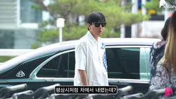 Kim Nam Gil mengenakan kemeja putih bercorak biru yang dipadukan dengan celana panjang hitam. Dia turun dari mobil dengan ekspresi terkejut.