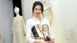 Laura Basuki mengenakan shirt dress dominan putih saat menghadiri pameran busana karya Didi Budiarjo di Museum Tekstil, Kamis (15/1/2015). (Liputan6.com/Panji Diksana)