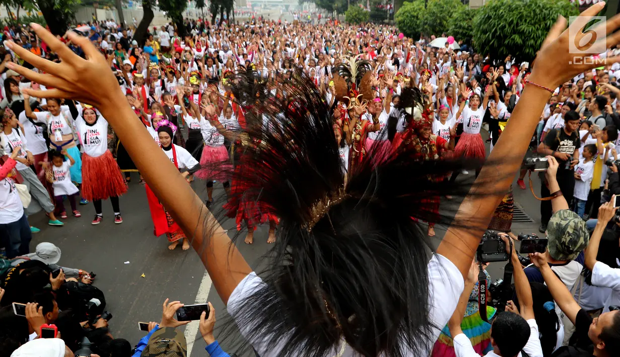 Seorang instruktur membawakan tarian tradisional Indonesia saat Car Free Day di Senayan, Jakarta, Minggu (13/08). Peserta penari adalah keluarga biasa yang punya antusias tinggi terhadap kebudayaan Indonesia. (Liputan6.com/Fery Pradolo)