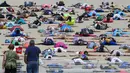 Sejumlah orang melihat peserta yang terbaring diatas pasir untuk membuat "Sand Angels" atau Malaikat Pasir di Pantai Stearns Park, Ludington (10/6). Sebanyak 1.414 orang ikut berpatisipasi dalam acara ini. (Youngrae Kim / Muskegon Chronicle via AP)