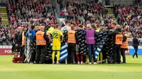 Pemain Timnas Denmark dan Timnas Ukraina membentuk lingkaran di sekitar Christian Eriksen yang jatuh pingsan di tengah pertandingan di Odensen, Denmark, Minggu (07/06/2026) malam WIB. (Bo Amstrup/Ritzau Scanpix via AP)