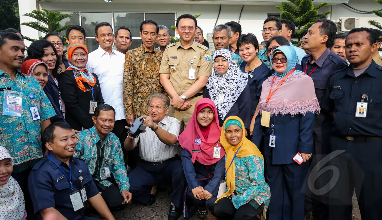 Presiden Joko Widodo ditemani Mendikbud Anies Baswedan dan Gubernur DKI Basuki Tjahaja Purnama berfoto bersama para guru usai meninjau pelaksanaan Ujian Nasional (UN) di SMKN 1, Jakarta, Selasa (14/4/2015). (Liputan6.com/Faizal Fanani)