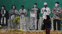 Warga melintas di depan gambar pemimpin agama di Lapangan Kebagusan, Jakarta, Rabu (15/2). Jelang menggunakan hak pilihnya pada Pilkada, Ketua Umum PDI-P Megawati Soekarnoputri menggoreskan tinta pada salah satu gambar. (Liputan6.com/Helmi Fithriansyah)