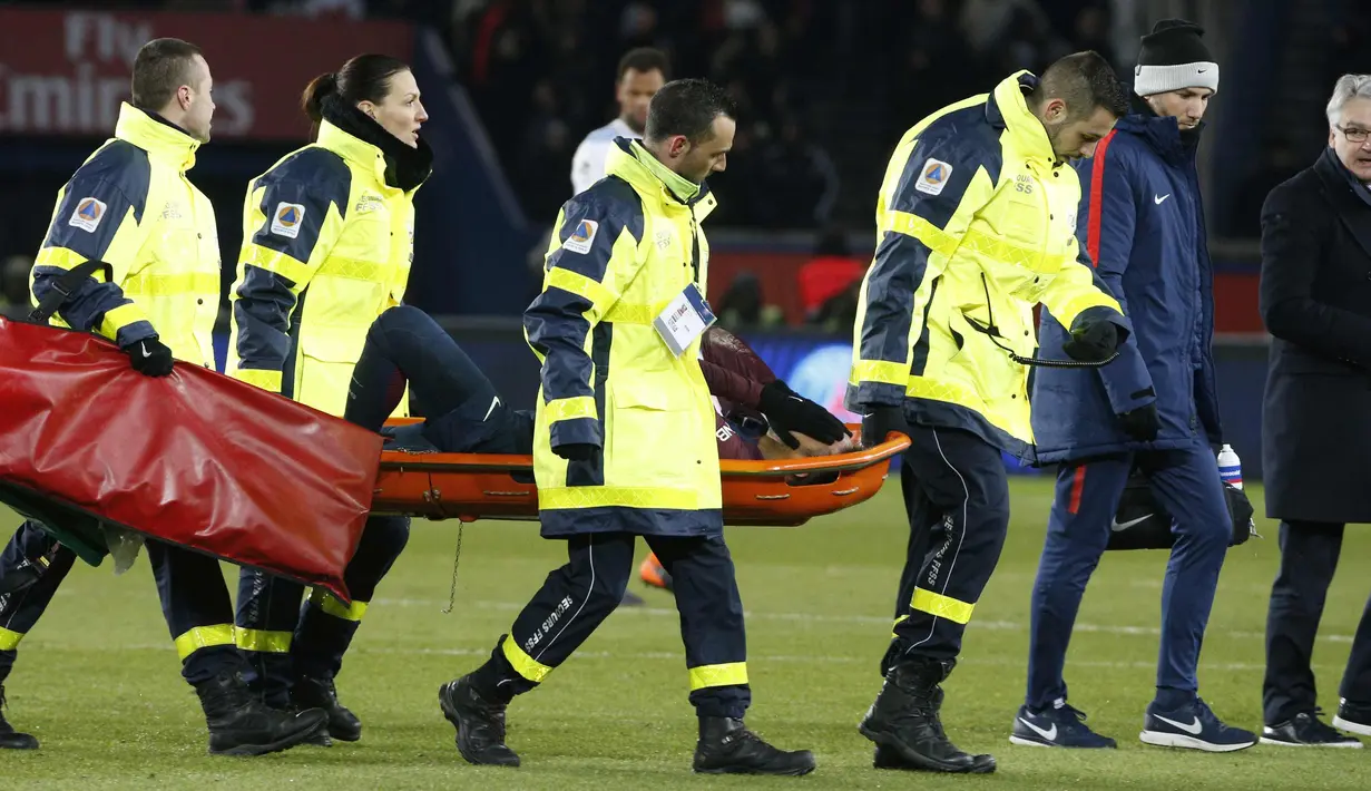 Penyerang PSG, Neymar Jr saat ditandu keluar lapangan oleh tim medis pada pertandingan melawan Marseille di Liga Prancis di Stadion Parc des Princes, (25/2). PSG menang 3-0 di pertandingan tersebut. (AFP Photo/Geoffroy Van Der Hasselt)