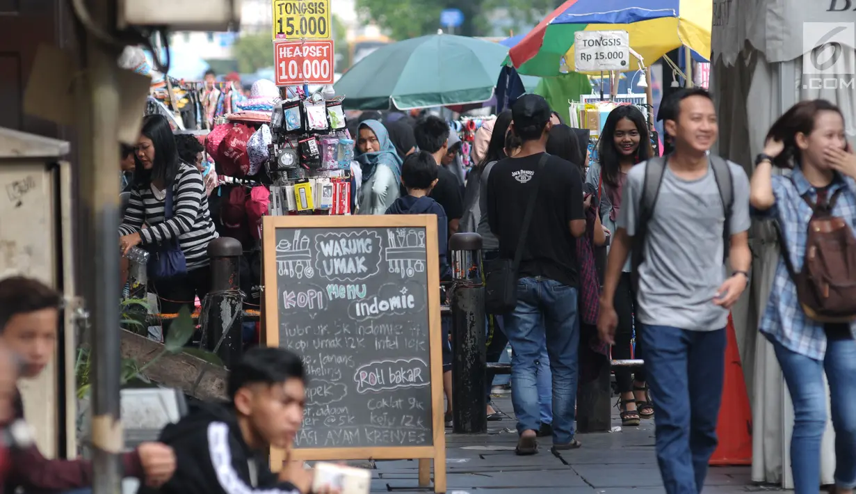 Sejumlah PKL menggelar dagangan di trotoar sekitar Museum Fatahillah, Jakarta, Rabu (20/6). Libur lebaran 2018, sejumlah PKL memenuhi kawasan Kota Tua Jakarta, akibatnya jalan di sekitar Museum Fatahillah semrawut. (Liputan6.com/Helmi Fithriansyah)