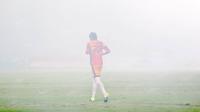 Kiper  Madura United, Hery Prasetyo menembus kumpulan asap dari flare saat melawan Persiba Balikpapan pada laga Torabika SC2016 di Stadion Gelora Bangkalan, Senin(13/6/2016).  (Bola.com/Nicklas Hanoatubun)