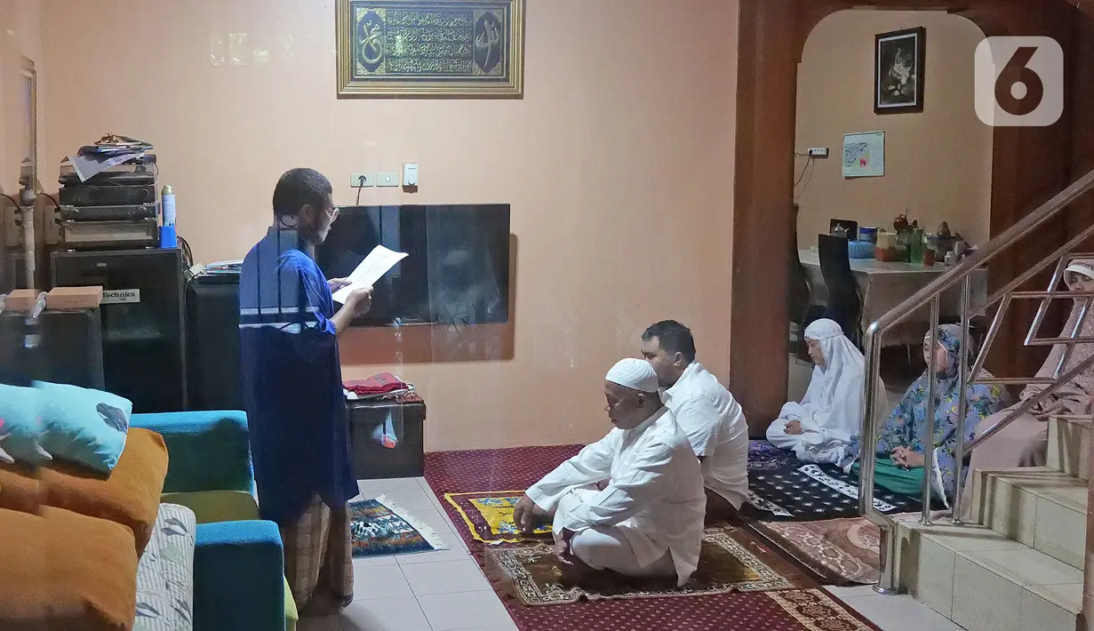 Warga mendengarkan khotbah saat melaksanakan salat Idul Fitri di kediamannya kawasan Mekarsari, Depok, Jawa Barat, Minggu (24/5/2020). Warga menjalankan salat Idul Fitri di rumah saat pandemi COVID-19. (Liputan6.com/Herman Zakharia)