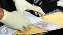 Barang bukti berupa uang dolar Singapura yang berhasil diamankan KPK saat OTT terhadap Panitera Pengganti PN Jakpus, Jakarta, Jumat (1/7). (Liputan6.com/Helmi Afandi)