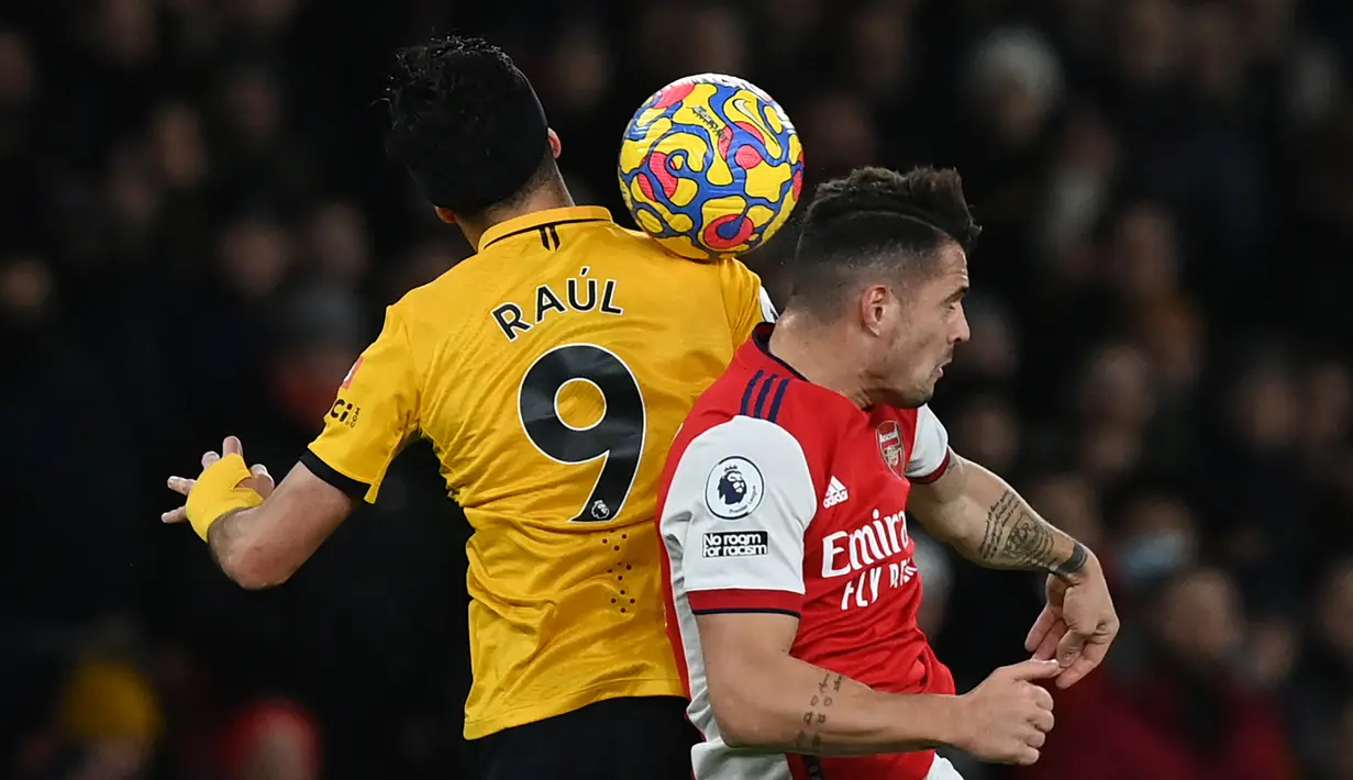 Striker Wolverhampton Wanderers Raul Jimenez berebut bola dengan gelandang Arsenal Granit Xhaka pada partai tunda pekan ke-20 Liga Inggris di Emirates Stadium, Jumat (25/2/2022) dini hari WIB. Arsenal menang dramatis 2-1 berkat dua gol di menit akhir. (Glyn KIRK / AFP)