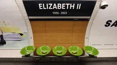 Sebuah tanda di stasiun metro bawah tanah Paris "George V" diganti dengan plakat bertuliskan "Elizabeth II 1926-2022", di stasiun Metro Paris George V, di Paris pada 19 September 2022. Stasiun metro George V di Paris untuk sementara berganti nama menjadi stasiun Elizabeth II. (Photo by Thomas SAMSON / AFP)