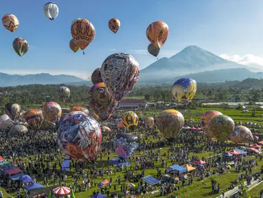 Pemandangan udara menunjukkan balon udara yang dihiasi motif tradisional sebelum diluncurkan selama festival tahunan yang diadakan untuk merayakan Hari Raya Idul Fitri, di desa Semayu, Wonosobo, Jawa Tengah pada Senin 23 Maret 2026. Festival balon udara tradisional kembali digelar di Desa Semayu, Wonosobo. (DEVI RAHMAN/AFP)