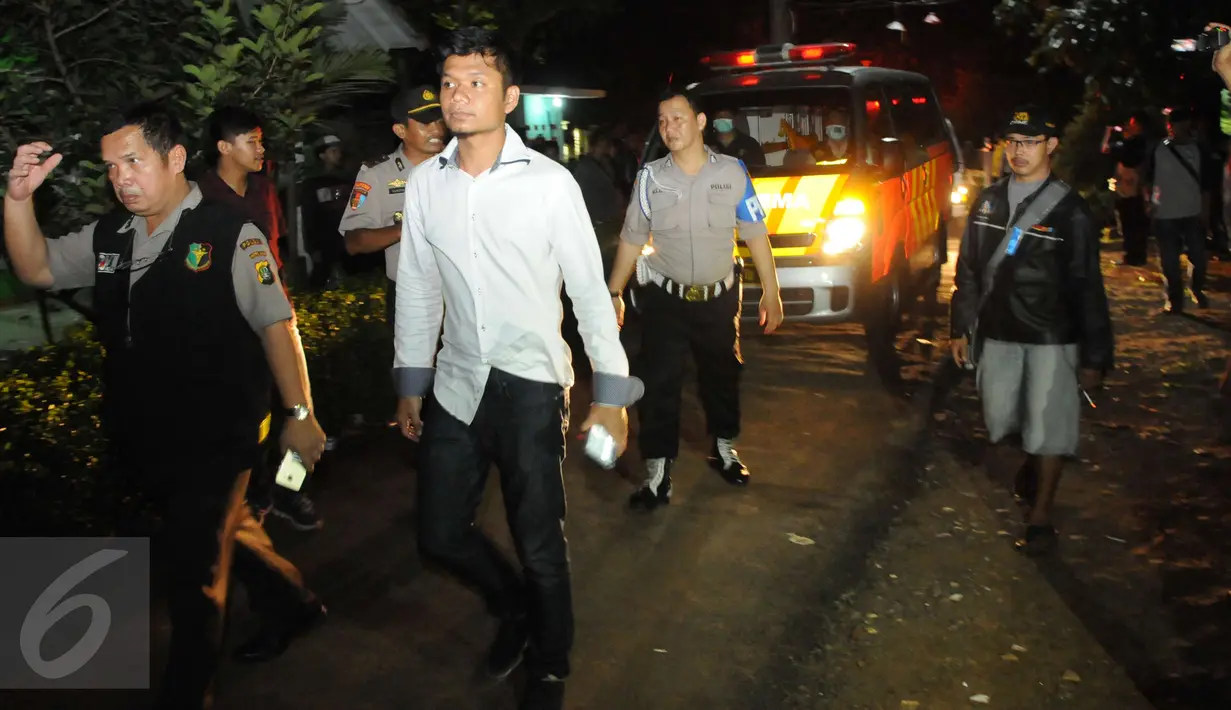 Petugas mengawal ambulan yang berisi mayat terduga teroris di Setu, Tangerang Selatan, Banten, Rabu (21/12). Densus 88 terlibat baku tembak yang akhirnya menewaskan tiga orang terduga teroris. (Liputan6.com/Helmi Afandi)