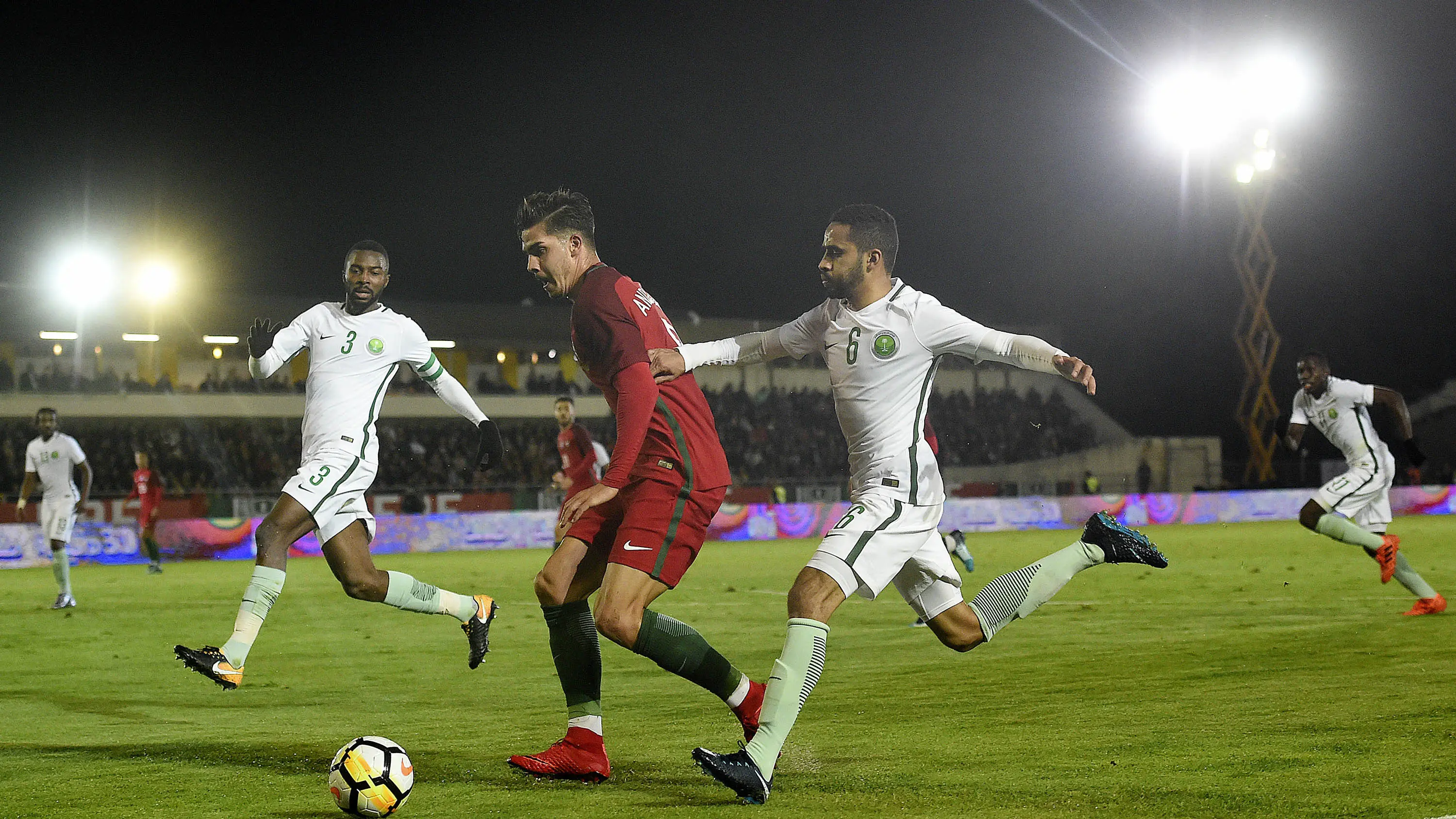 Striker Portugal, Andre Silva, berebut bola dengan gelandang Arab Saudi, Mohammed Alburayk, pada laga persahabatan di Stadion Municipal do Fontelo, Sabtu (11/11/2017). Portugal menang 3-0 atas Arab Saudi. (AFP/Francisco Leong)