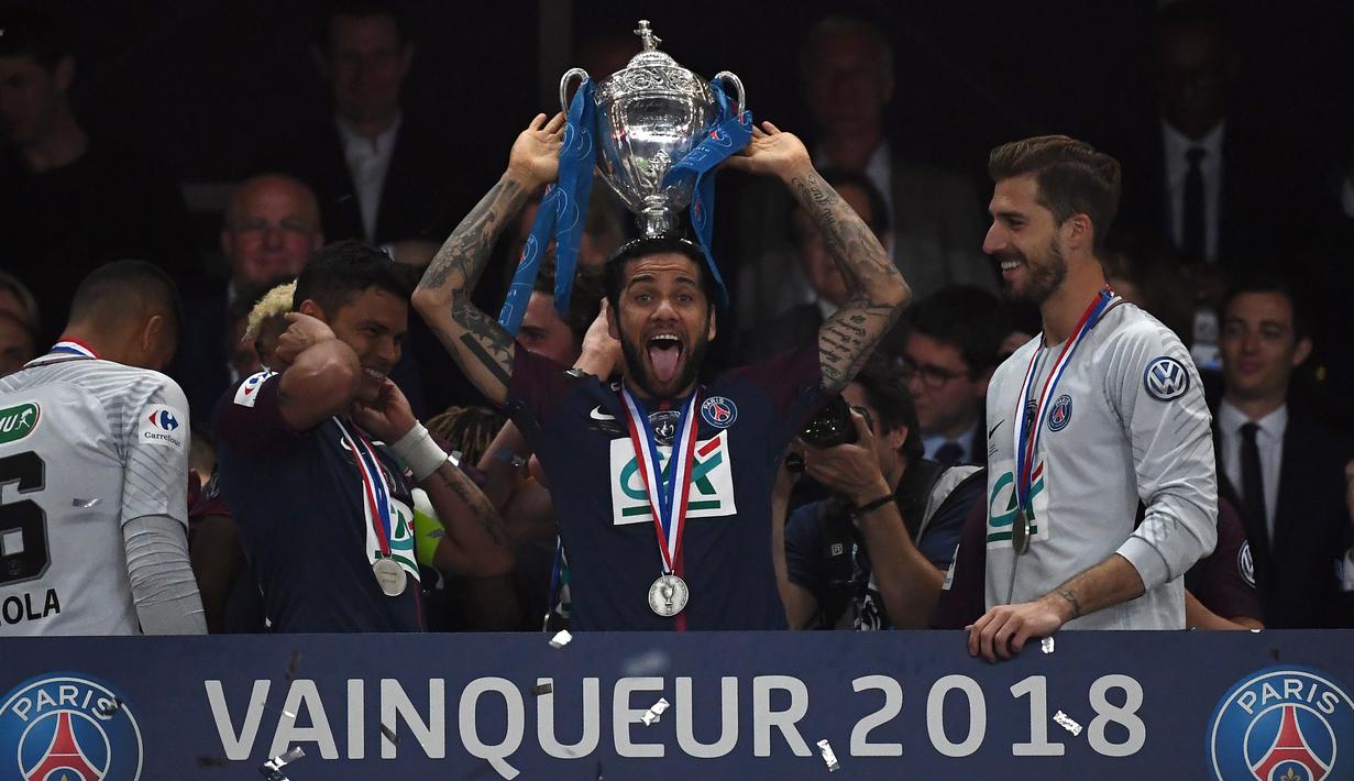 Bek Paris Saint-Germain, Daniel Alves berpose dengan trofi seusai menjuarai Piala Prancis (Coupe de France) di Stade de France, Rabu (9/5). PSG menang 2-0 atas Tim divisi tiga, Les Herbiers pada final Piala Prancis. (AFP/FRANCK FIFE)