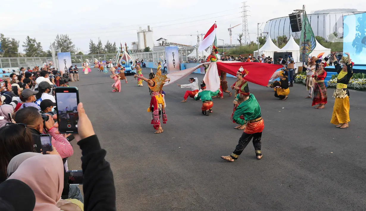 Peserta berparade dalam pagelaran Jakarnaval 2022 di Jakarta International Eprix Circuit, Ancol, Minggu (14/8/2022). Gelaran Jakarnaval 2022 yang mengangkat tema "Kekayaan Intelektual Nusantara untuk Dunia" tersebut menampilkan parade komunitas pegiat seni budaya, marching band, dan kendaraan hias. (Liputan6.com/Herman Zakharia)