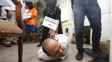 Tersangka melakukan adegan rekonstruksi pembunuhan pasutri di Benhil, Jakarta, Senin (9/10). 26 adegan dilakukan dalam rekonstruksi kasus yang menyebabkan tewasnya Zakaria Husni (57) dan istrinya Zakiya Husni (52). (Liputan6.com/Immanuel Antonius)