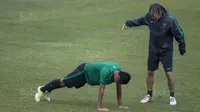 Gelandang Timnas Indonesia, Evan Dimas, diminta pelatih fisik, Miguel Gandia, untuk push up usai latihan di Stadion UKM, Selangor, Sabtu (19/8/2017). Evan kalah saat bermain crossbar dengan Miguel. (Bola.com/Vitalis Yogi Trisna)