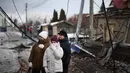 Hingga kini, upaya perundingan damai kedua negara, Rusia dan Ukraina, yang dimediasi Amerika Serikat masih belum menemukan titik temu. Tampak dalam foto, warga setempat berdiri di lokasi serangan udara di Sofiivska Borshchagivka, wilayah Kyiv pada Minggu 22 Februari 2026. (Henry NICHOLLS/AFP)