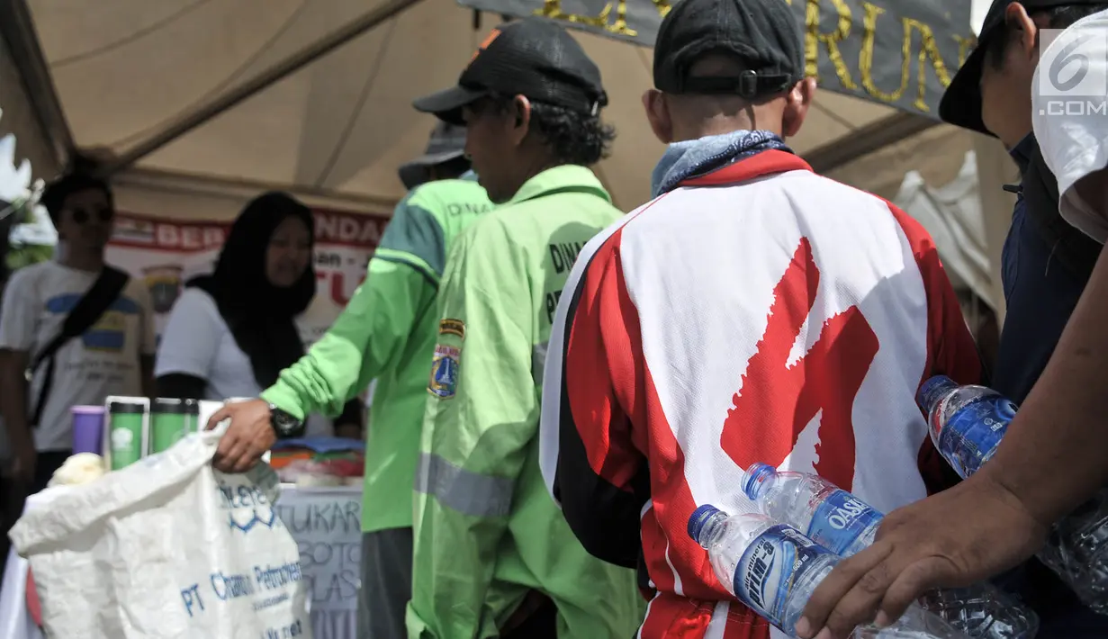 Antrean warga saat menukarkan botol bekas di stan ENVIRUN selama hari bebas kendaraan atau car free day (CFD) di Jakarta, Minggu (8/4). Tiga botol bekas bisa ditukar dengan hadiah seperti bibit tanaman, tumbler, dan handuk. (Merdeka.com/Iqbal Nugroho)