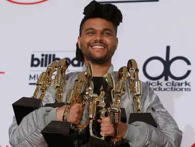 Penyanyi The Weeknd saat membawa sejumlah piala penghargaannya di  ajang Billboard Music Awards 2016, T-Mobile Arena, Las Vegas, (22/5). The Weeknd berhasil membawa pulang tujuh piala pada acara tersebut. ( REUTERS/Steve Marcus)