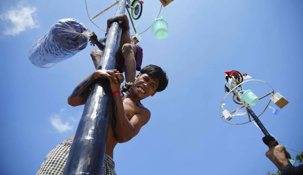Seorang peserta saat mengikuti lomba panjat pinang kolosal yang diadakan untuk merayakan HUT ke-80 Kemerdekaan Indonesia, di Pantai Ancol, Jakarta, Minggu 17 Agustus 2025. (AP Photo/Tatan Syuflana)