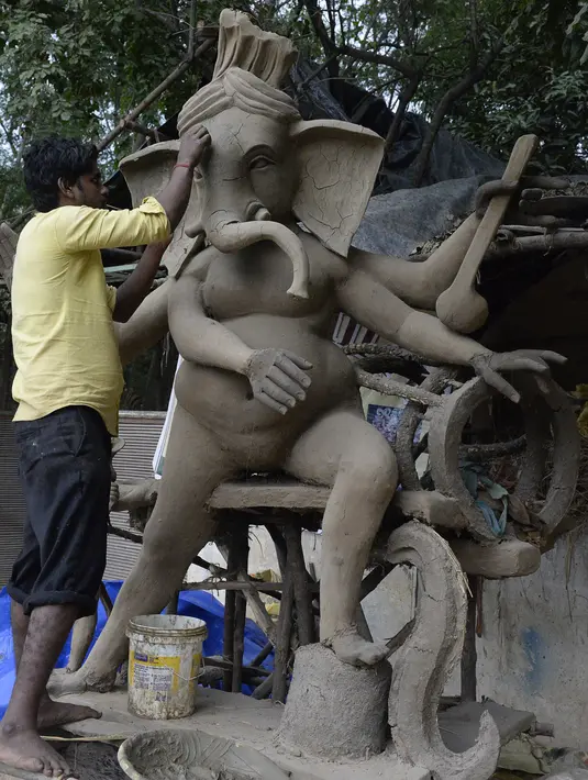 Seorang seniman India menyelesaikan pembuatan patung Dewa Hindu, Lord Ganesh di sebuah lokakarya di Hyderabad (19/8/2019). Festival Ganesh Chaturthi yang diadakan selama sebelas hari akan dirayakan mulai 2 September 2019. (AFP Photo/Noah Seelam)