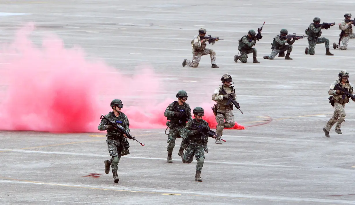 Tentara pasukan khusus Taiwan berlari melewati asap selama latihan tahunan Han Kuang di sebuah pangkalan udara di Taichung, Kamis (7/6). Latihan militer tahunan terbesar ini digelar di tengah kian agresifnya China terhadap Taiwan. (AP/Chiang Ying-ying)