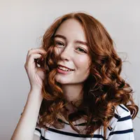 Seorang perempuan dengan rambut keriting bergelombang (Foto Dok: Freepik/lookstudio).
