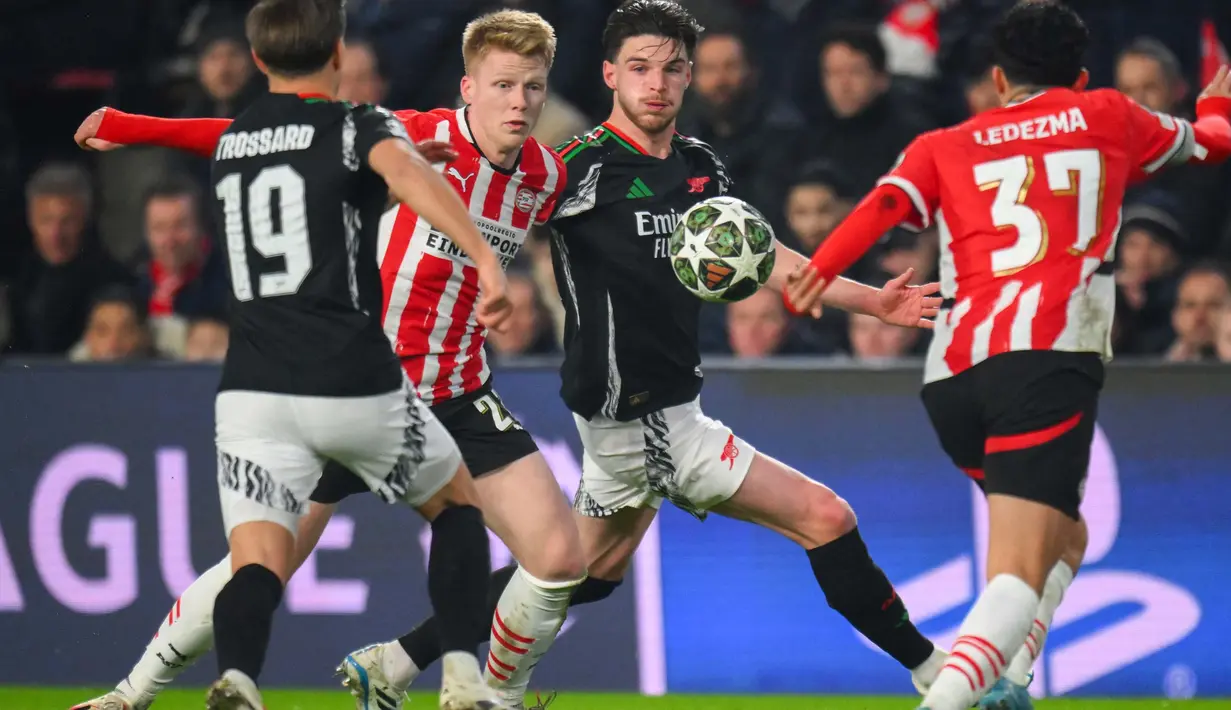 Gelandang PSV Eindhoven Jerdy Schouten (tengah kiri) berebut bola dengan Declan Rice (Arsenal) saat leg pertama 16 besar Liga Champions 2024/2025 yang digelar di Philips Stadion, Eindhoven, pada tanggal 4 Maret 2025 waktu setempat atau Rabu (5/3/2025) dini hari WIB. (JOHN THYS/AFP)